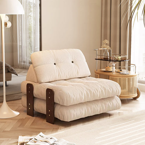 Cream-colored corduroy rachman sleeper armchair with dark wood frame accents as single seater bed
