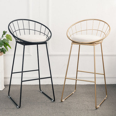 Two rafael sphere bar stools with wireframe metal frames in black and gold and cushioned white seats