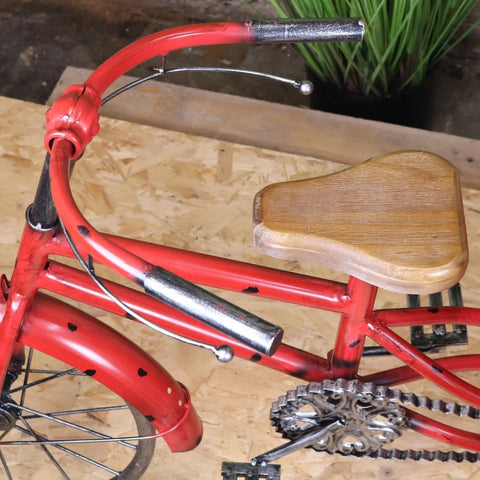 Red metal tricycle ornament with wooden seat and heart-shaped decals in rahi vintage style design