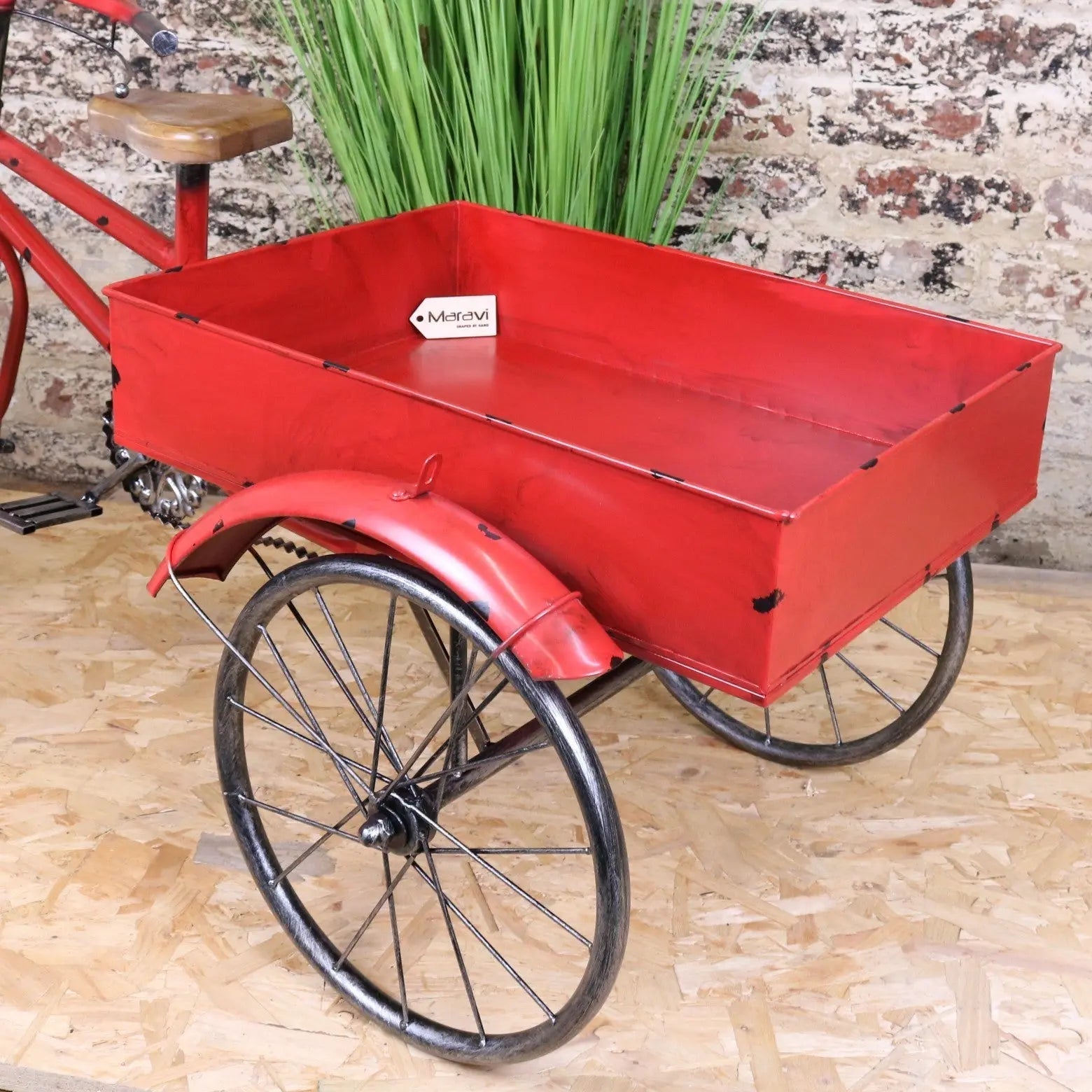 Red painted metal rahi vintage style tricycle ornament with black spoked wheels and wooden seat vintage style