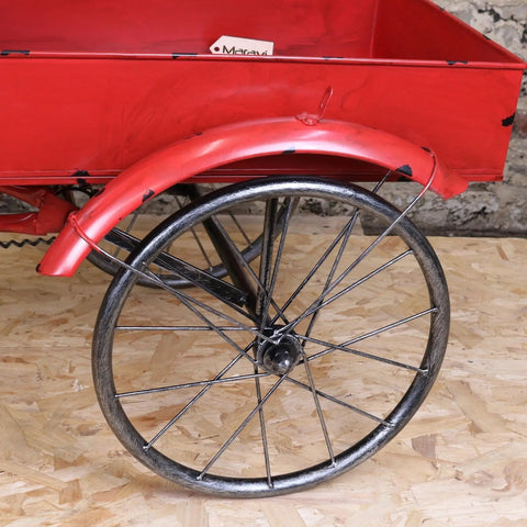 Red painted metal cart wheel with black spokes and matching fender on rahi vintage style mini tricycle ornament