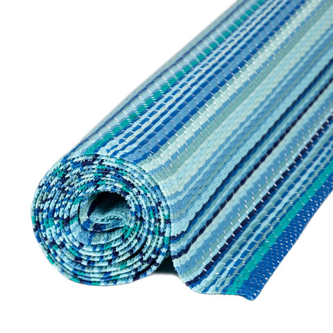 A rolled-up rainbow outdoor rug blue with a woven texture and blue teal stripes perfect for outdoor use