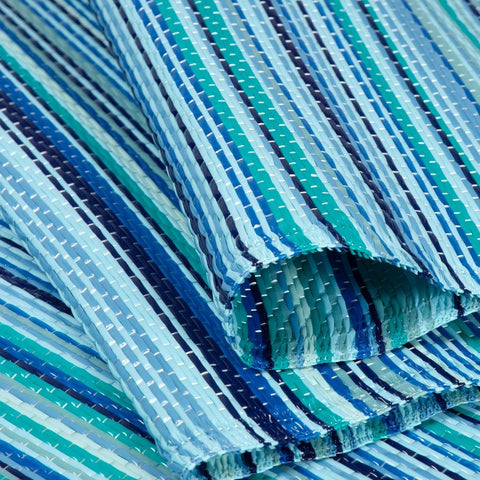 A woven plastic rainbow outdoor rug with teal navy and light blue stripes perfect as an outdoor rug blue option