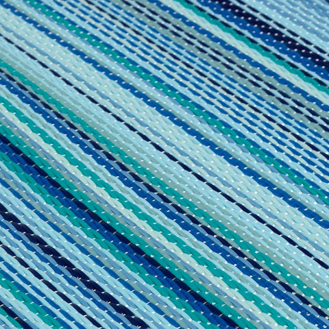 A woven rainbow outdoor rug blue with diagonal stripes in shades of blue teal and white perfect for outdoor use