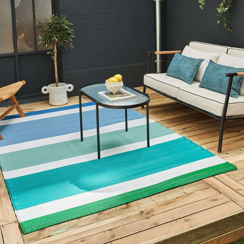 Vibrant rainbow outdoor rug blue with bold teal turquoise and green stripes separated by crisp white for outdoor use