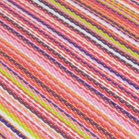 A vibrant rainbow outdoor rug pink with diagonal woven stripes in pastel and bold hues perfect for outdoor use