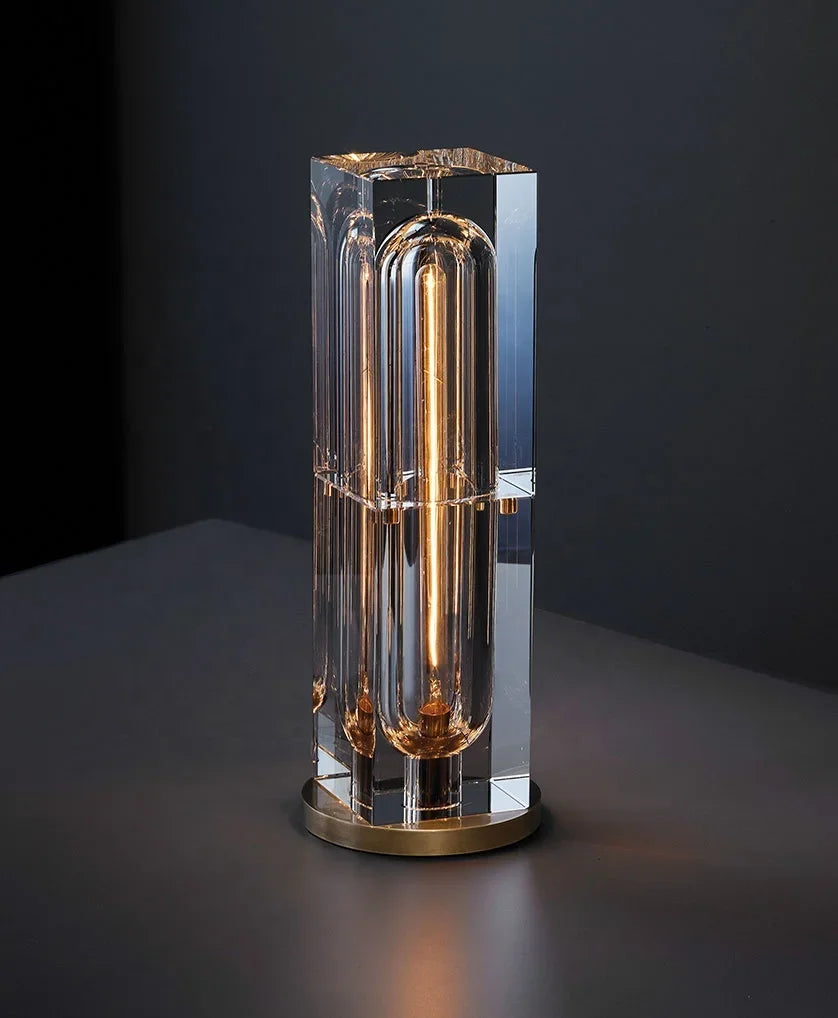 A modern Raito Light table lamp with a clear faceted crystal body and gold-toned metal accents
