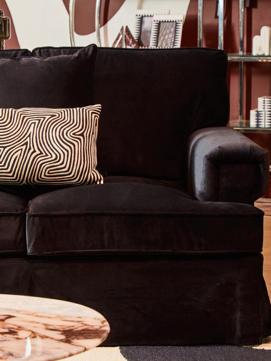 Ralph three seat black velvet sofa with a single patterned throw pillow showcasing a stylish black velvet design