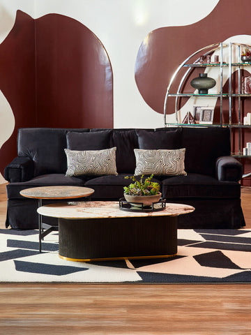 Ralph three seat black velvet sofa with two patterned throw pillows on a stylish black velvet sofa