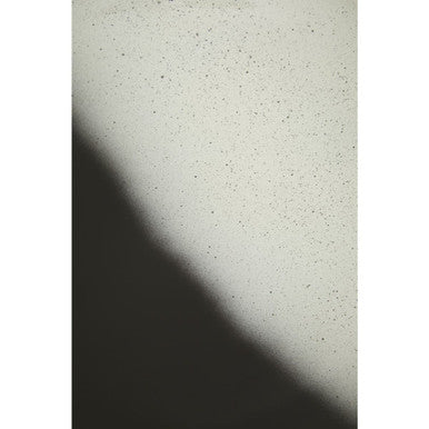 Close-up of a textured off-white ramus black and white ombre bowl with fine dark speckles on a white ombre surface