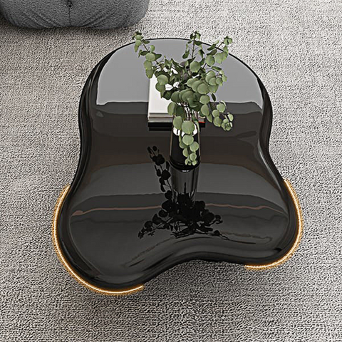 Ramy coffee table in black glossy ceramic with gold-trimmed edges and an organic asymmetrical shape