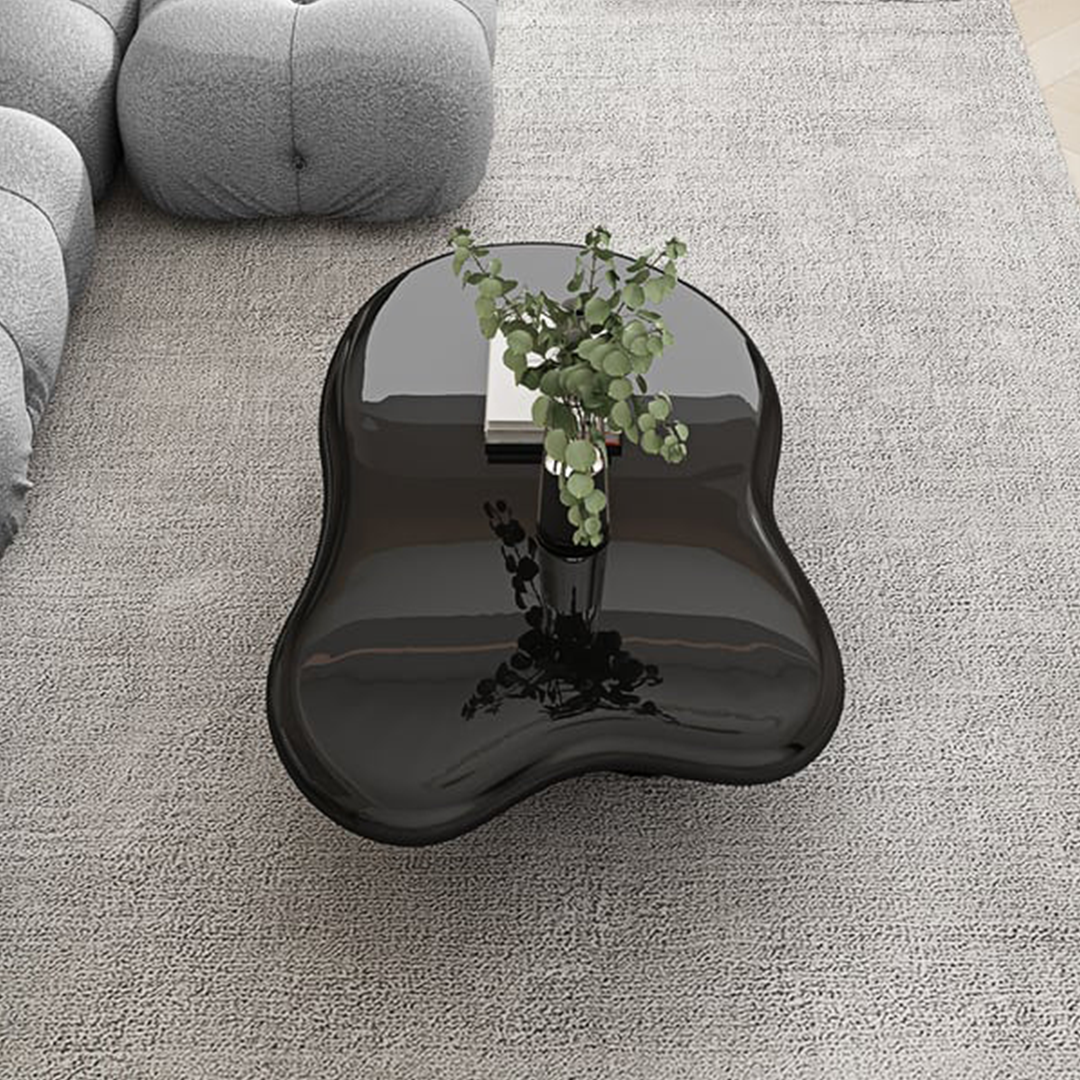 A sleek glossy black ramy coffee table with an organic freeform shape and reflective surface for stylish living rooms