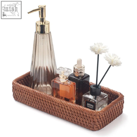 Brown woven rattan bathroom vanity tray holding bathroom essentials for toilet tank and hand towel storage