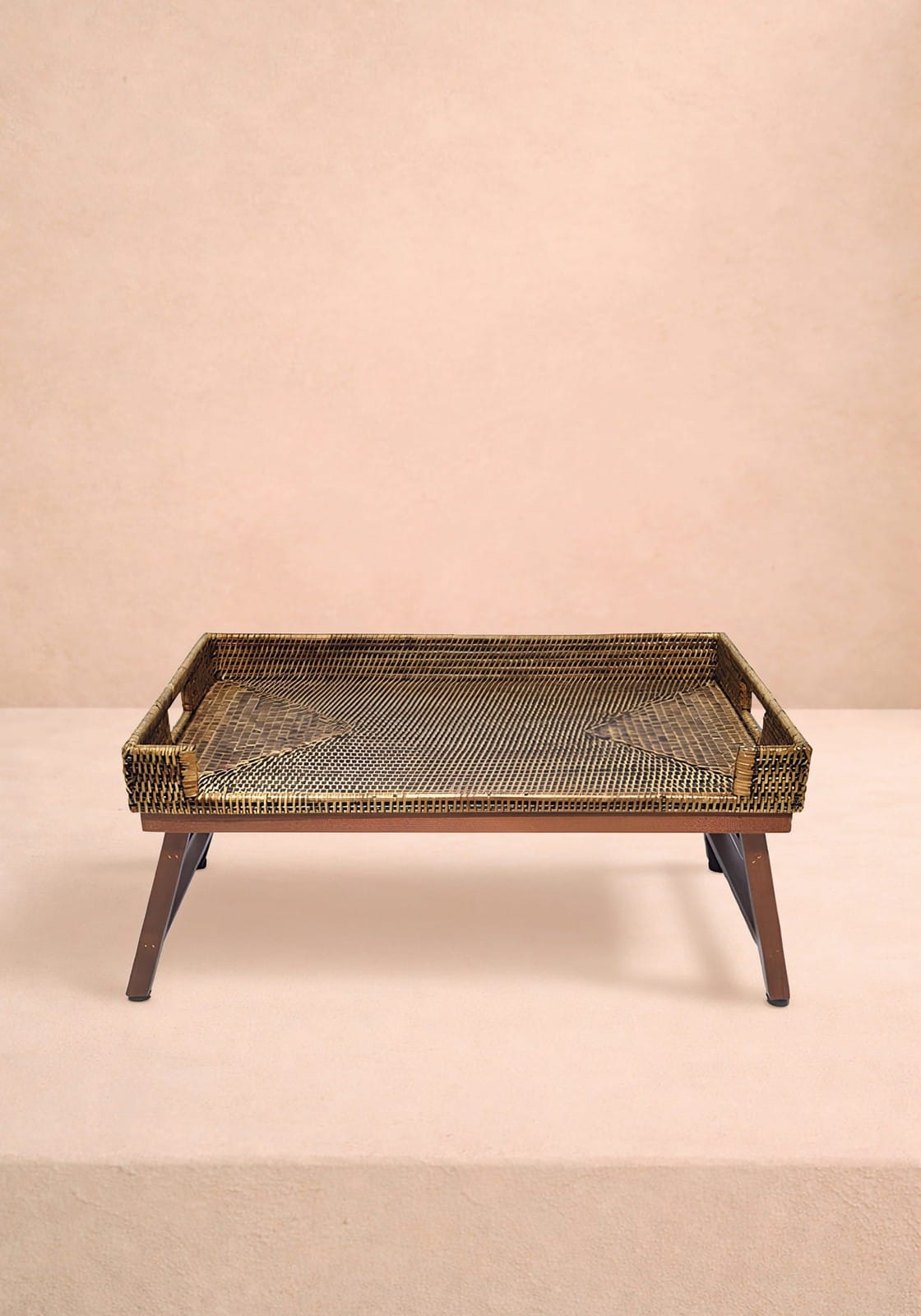 Brown rattan breakfast tray with a woven wicker surface and dark brown wooden frame and legs perfect for breakfast in bed