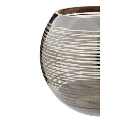 A sleek small rounded glass vase with silver geometric patterns etched on its transparent curved surface