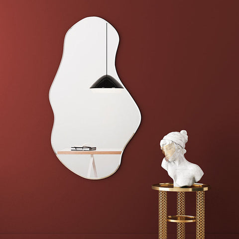 A sleek white re44 mirror with an organic freeform shape hanging on a deep red wall