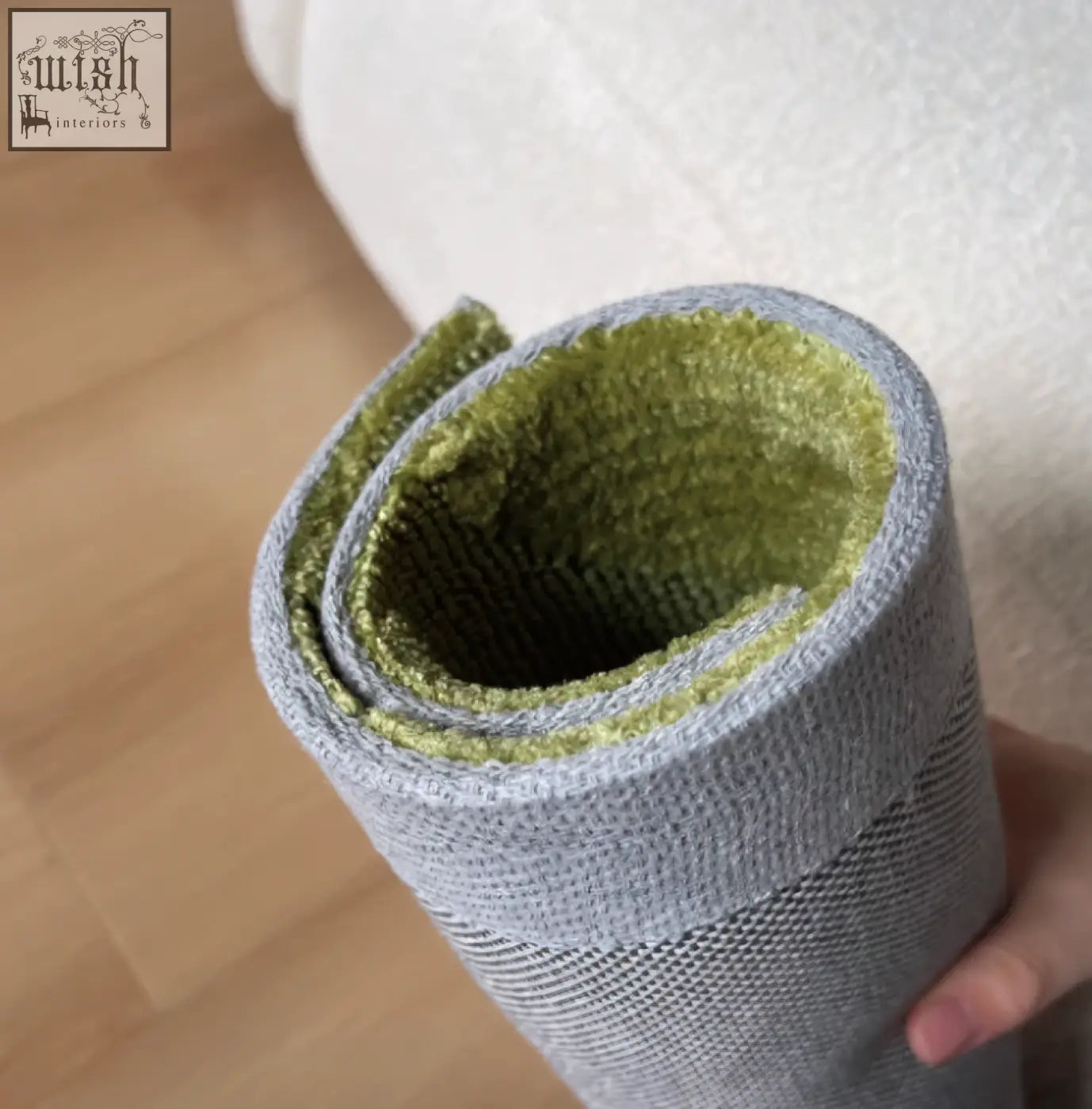 Rebekah living room rug in gray with soft olive green lining rolled neatly for storage perfect near coffee table set