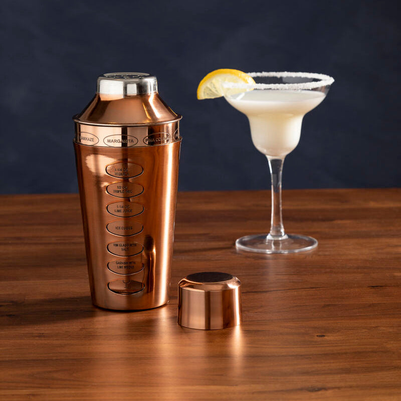 Rose gold cocktail shaker with engraved drink measurements and matching copper-colored lid for easy mixing