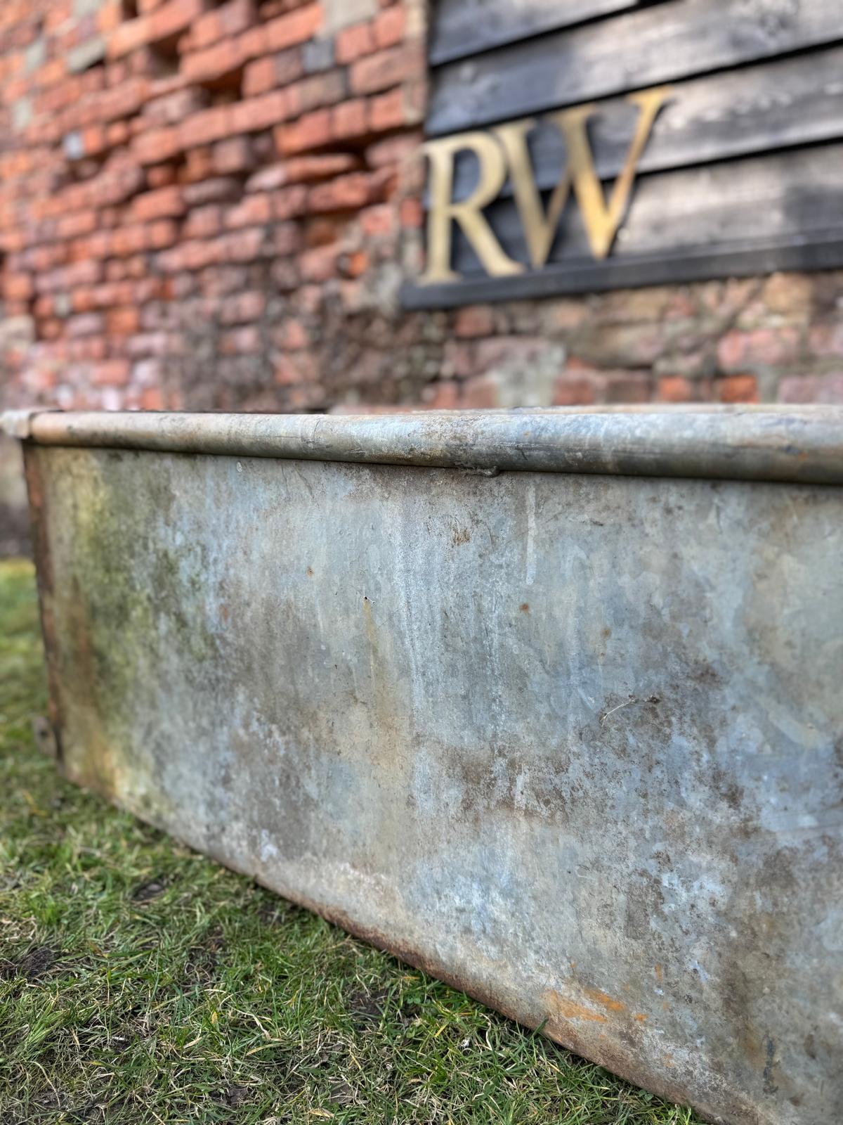 Weathered reclaimed galvanized trough planter with rustic patina and rusted edges for raised bed planting