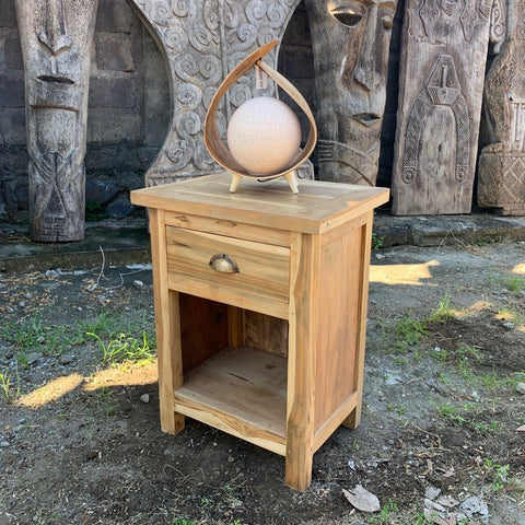 Light-colored teak wood bedside table with single drawer and open shelf perfect for bedroom storage