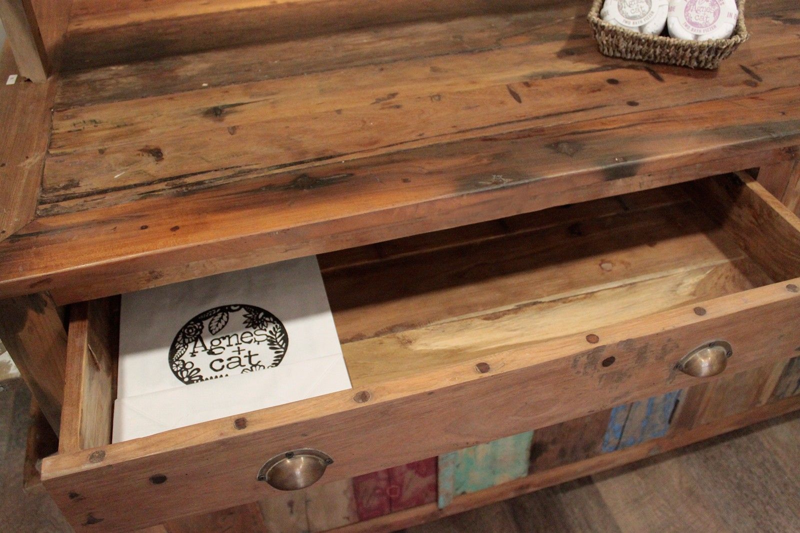 Rustic recycled teak wood centre display table with weathered finish and colorful patchwork panels on front
