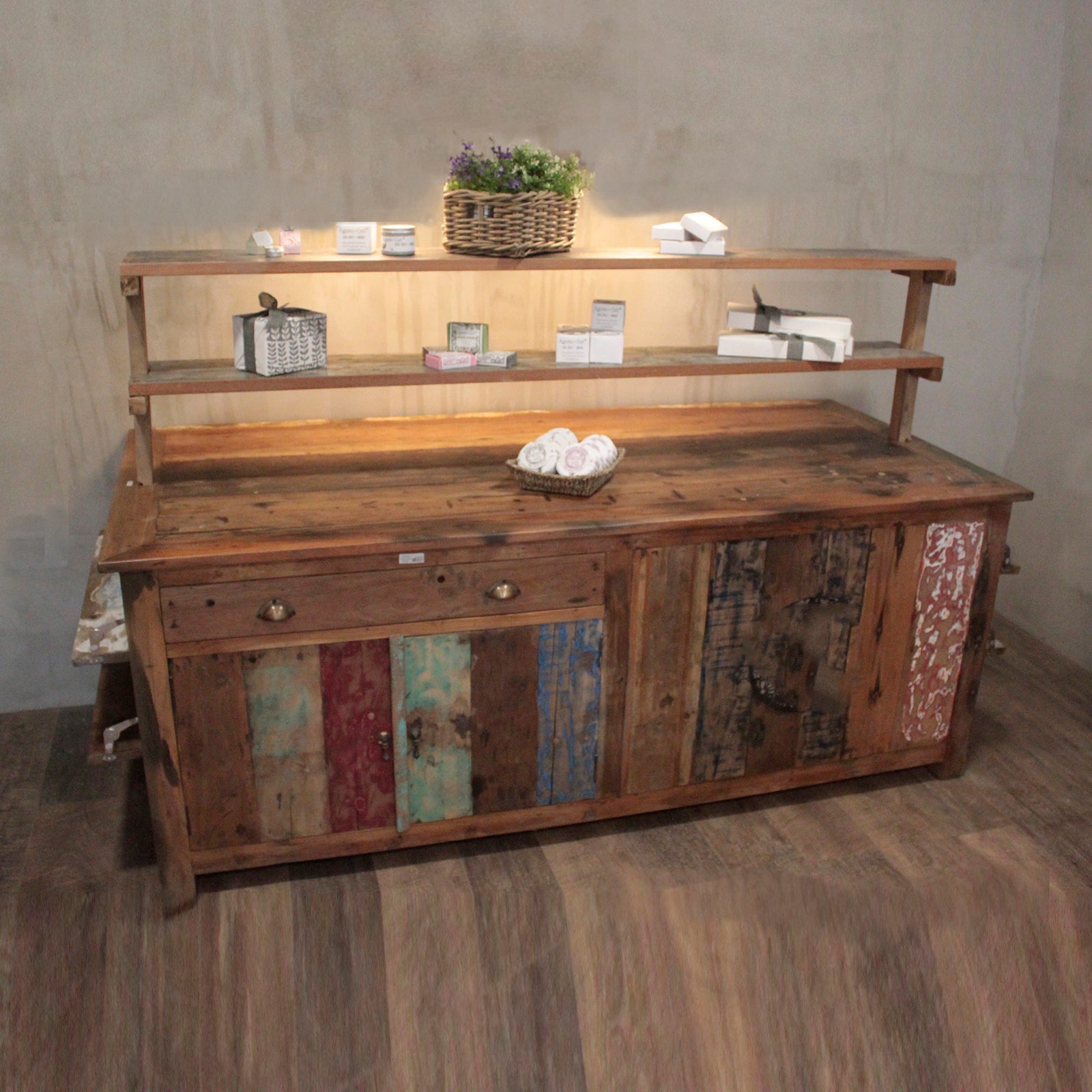 Rustic centre display table made of recycled teak wood with weathered multi-toned panels and thick natural wood top