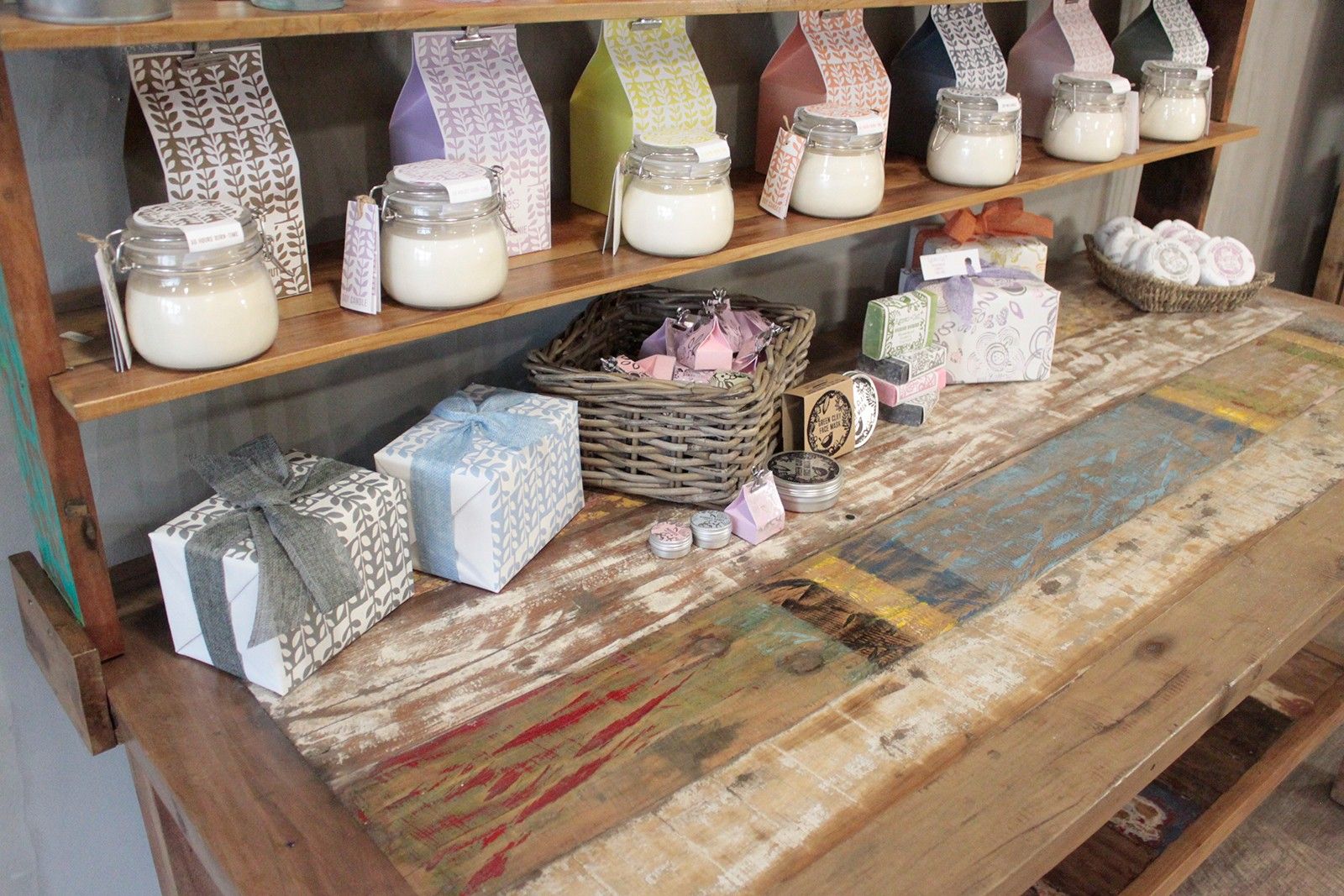 White candle in clear glass jar with white lid on recycled teak wood dining table with top shelf 180x80x80cm
