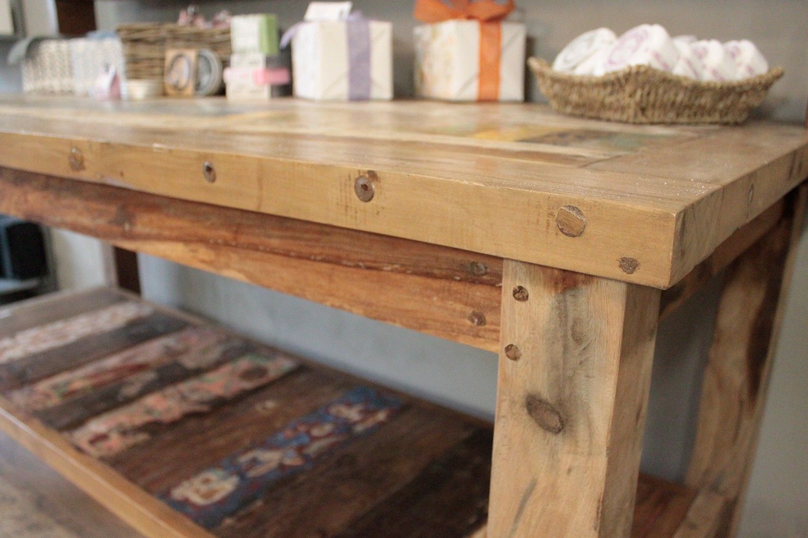 Rustic recycled teak wood dining table with top shelf natural light brown finish and metal fasteners visible grain