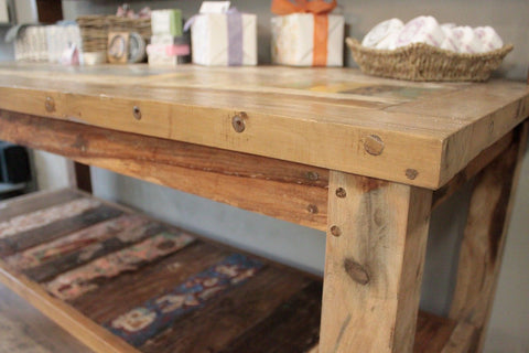 Rustic recycled teak wood dining table with top shelf natural light brown finish and metal fasteners visible grain