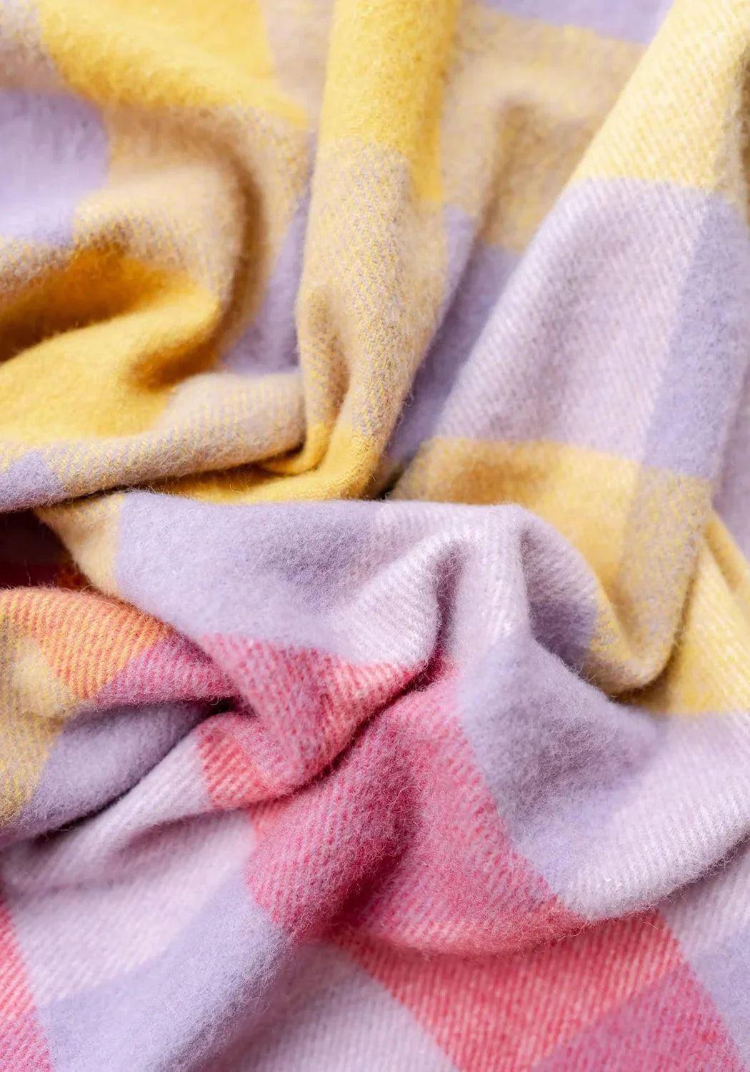 A soft cozy small picnic blanket in pastel lilac gradient gingham made from recycled wool with a textured weave