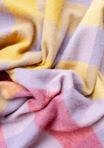 A soft cozy small picnic blanket in pastel lilac gradient gingham made from recycled wool with a textured weave
