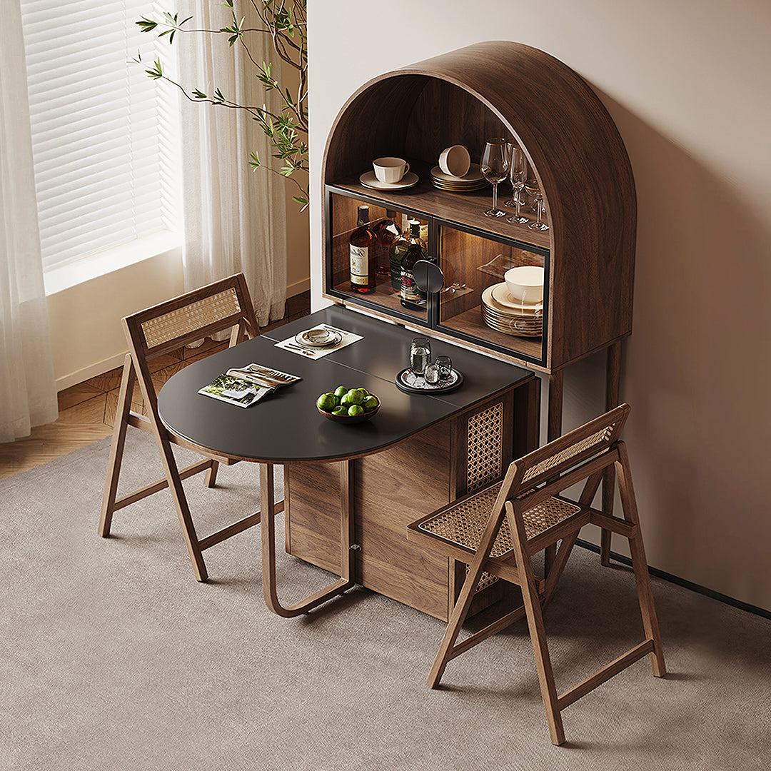 Modern oval reddy fold dining table with sleek black top and walnut wood frame paired with cane-backed folding chairs