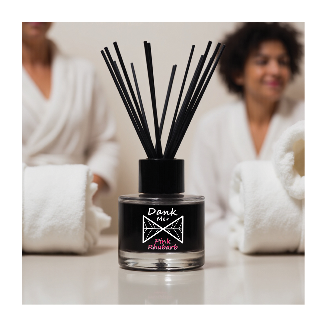 Black glass reed diffuser bottle with dank mer branding pink rhubarb scent black cap and slender reed sticks