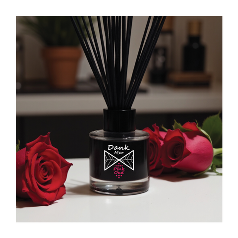 Black glass reed diffuser bottle with dank mer and pink oud branding filled with dark liquid and black reed sticks