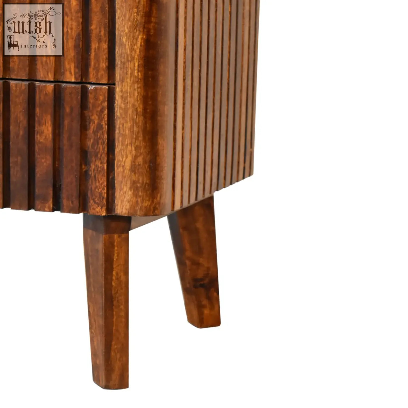 A reeve bedside table made of solid mango wood with ridged drawer fronts and tapered legs in mid-century style