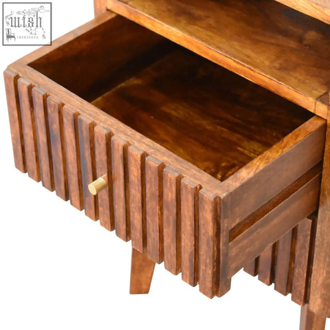 A warm-toned reeve bedside table in solid mango wood with ridged drawer fronts and a natural wood grain finish