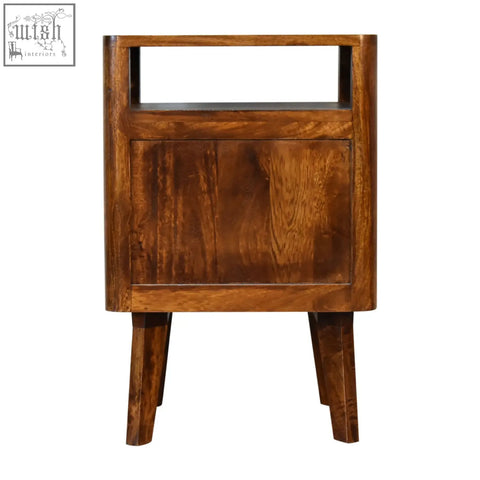 A reeve bedside table made of solid mango wood with a warm brown finish and ridged drawer fronts in a rustic style