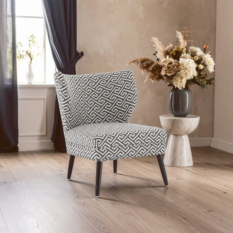 A modern regents park greek key design accent chair with black and white geometric fabric and sleek dark wooden legs
