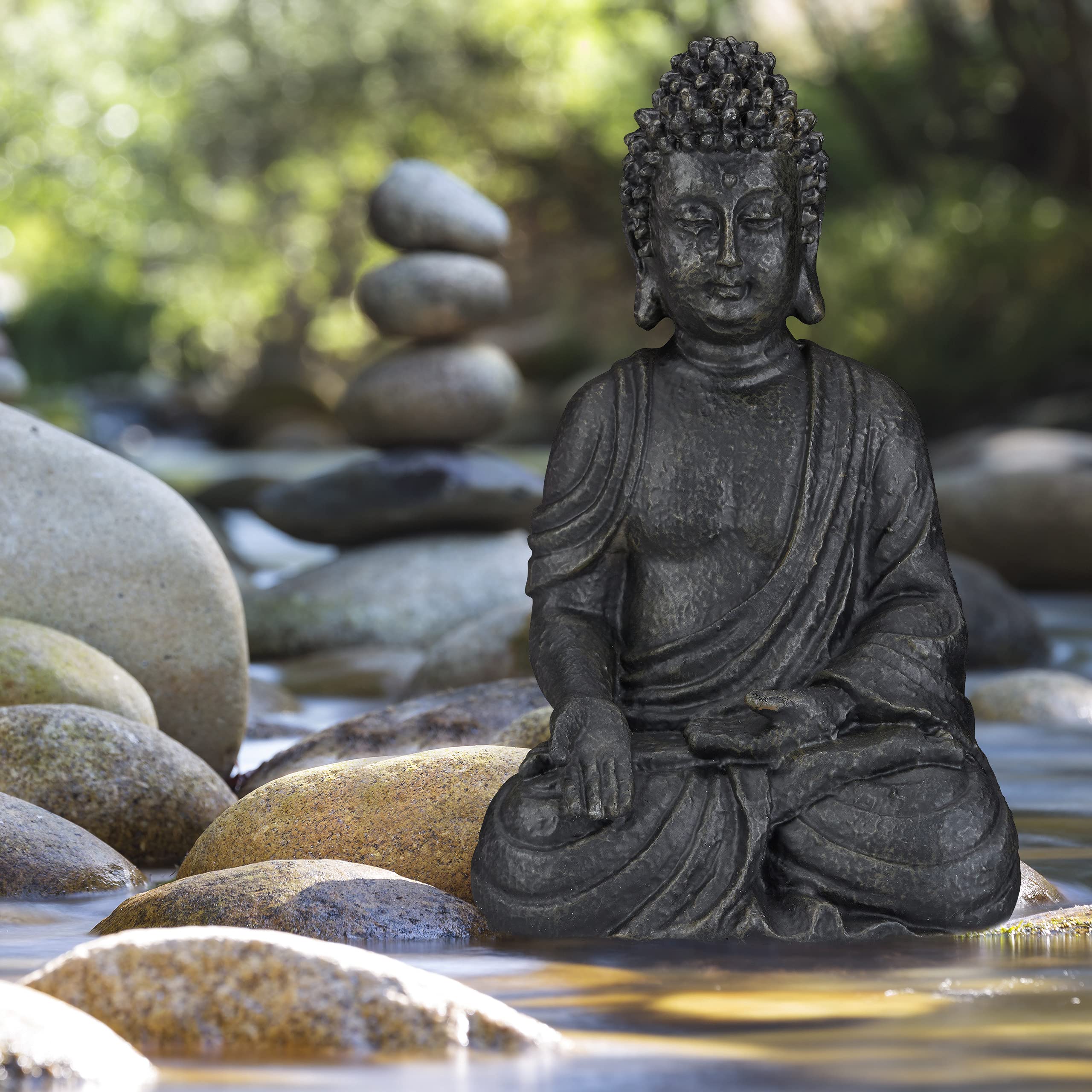 Dark bronze buddha figurine with intricate details seated on river stones for outdoor garden décor in light grey polyresin
