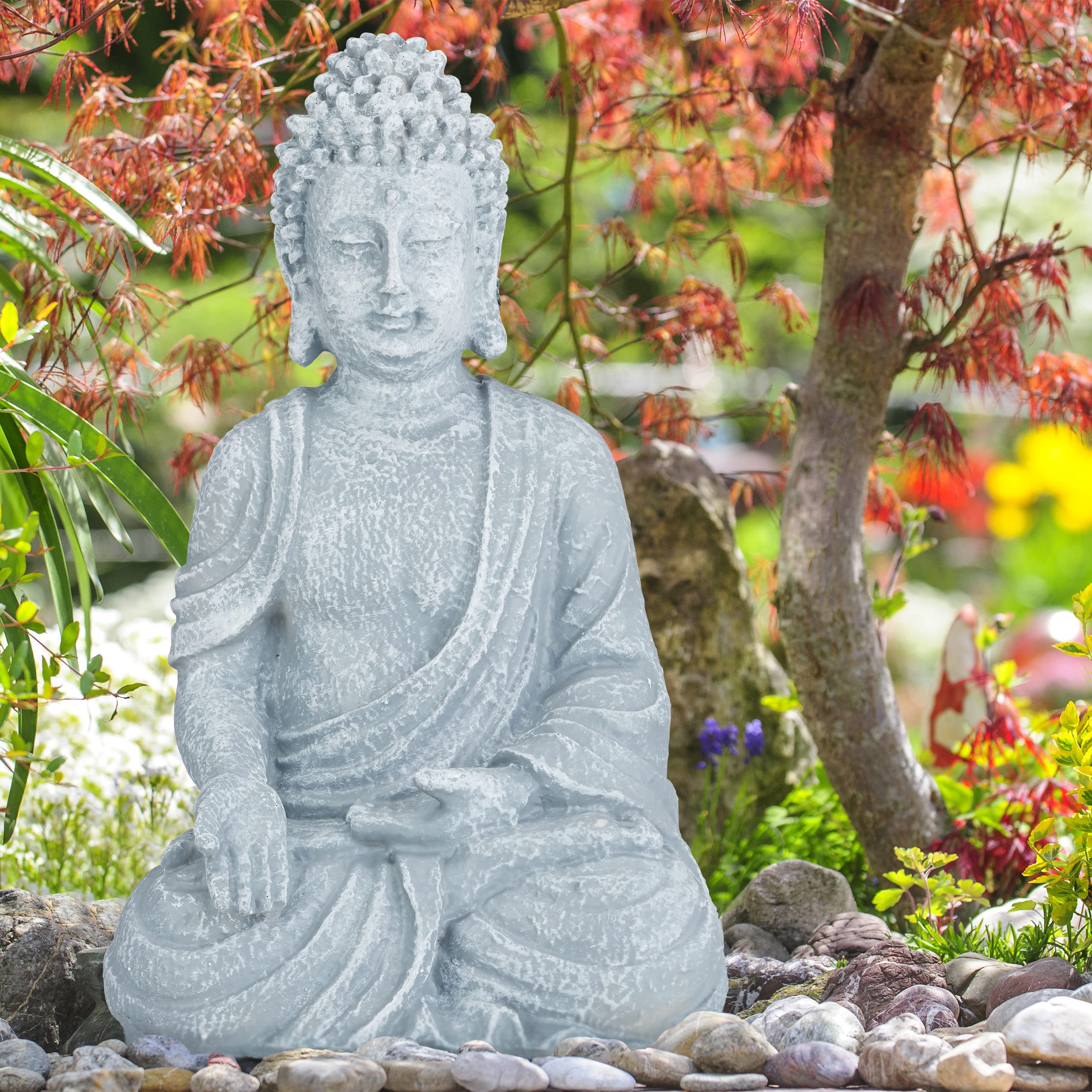 A serene light grey polyresin big zen buddha figurine with detailed robes for outdoor garden decor sits calmly