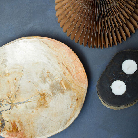 A round relic petrified wood tealight holder with a natural light beige and tan marbled stone slab design