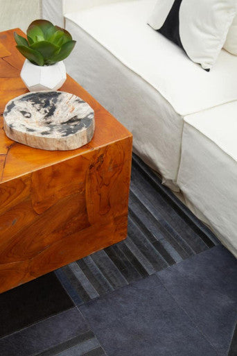 A polished warm-toned wooden side table with natural knots paired with a relic petrified wood bowl display