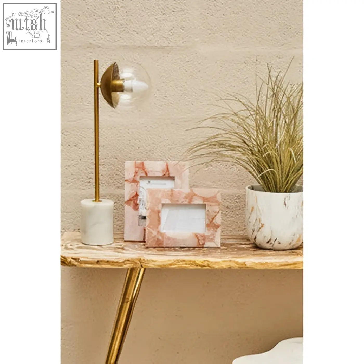 Marble-patterned picture frames with soft pink and white veining on a relic petrified wood console table display
