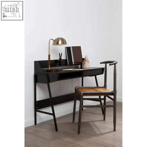Black minimalist desk with sleek metal legs and wood slat chair paired with relic petrified wood pyramid sculpture