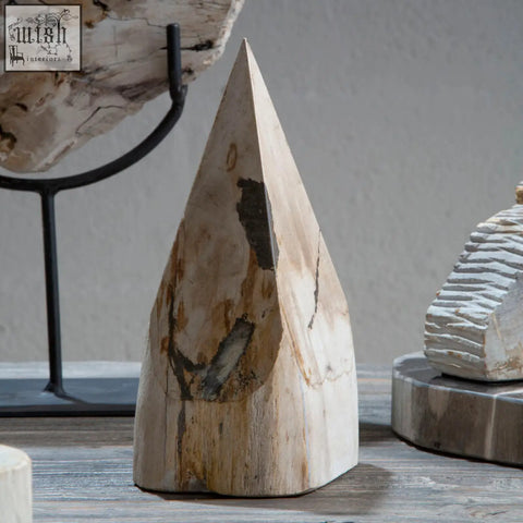 A light-colored wood pyramid sculpture with natural texture and darkened patches made from petrified wood
