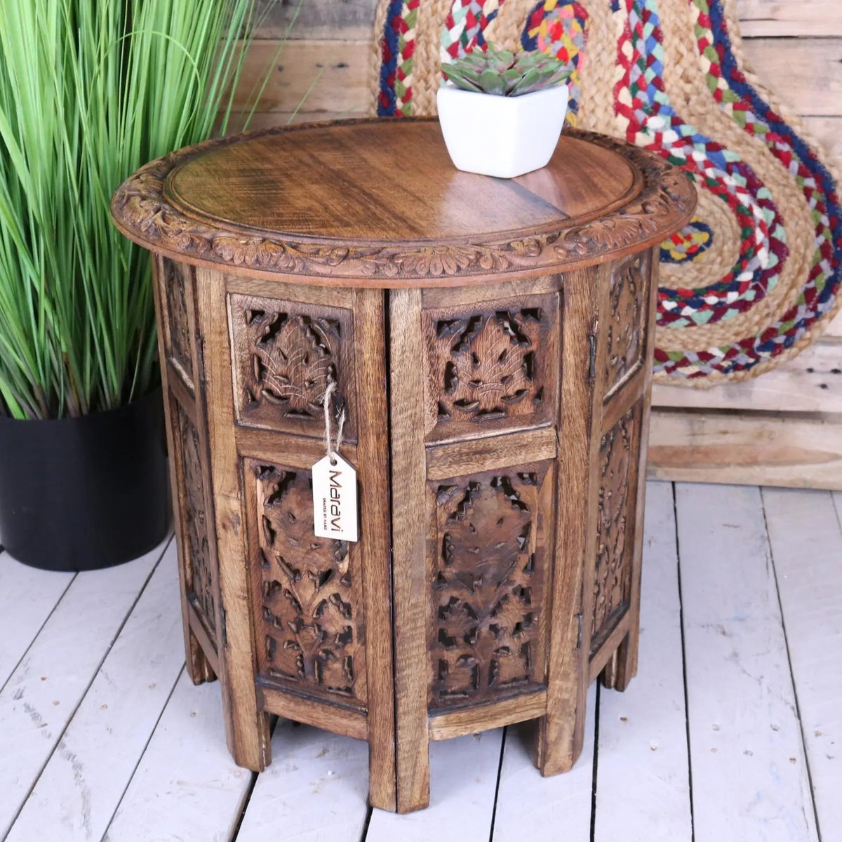 Hand carved rengali mango wood octagonal side table with intricate floral and figural leaf carving in medium brown tone