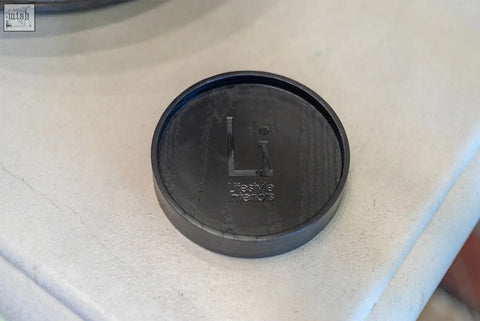 Black circular base tray coaster with textured surface and embossed li lifestyle trends logo replacement base tray