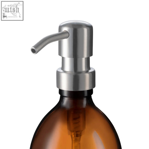 A sleek 304-grade stainless steel soap dispenser pump with a curved spout on an amber glass bottle