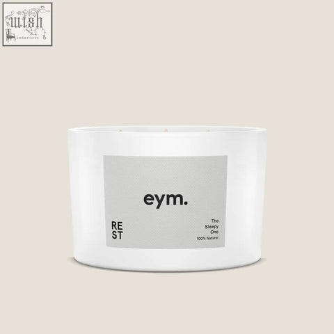 White cylindrical three wick candle in minimalist container with gray eym label the sleepy one natural scent rest