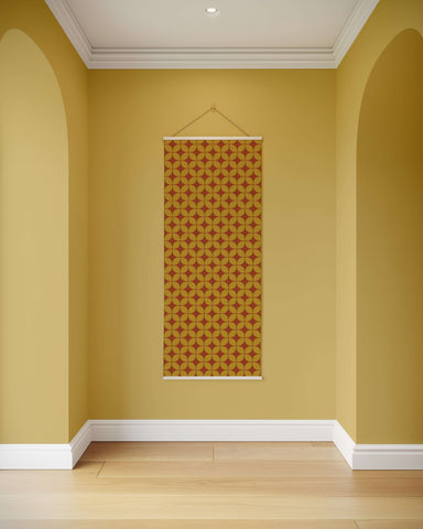 A rectangular retro diamond pattern tapestry with orange and mustard geometric design framed by white borders